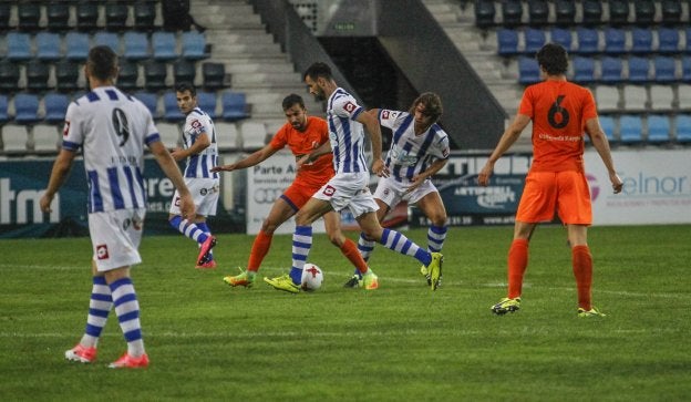 Cagigas conduce el balón ante un rival, apoyado por Luis Alberto y Vitienes, a la izquierda.