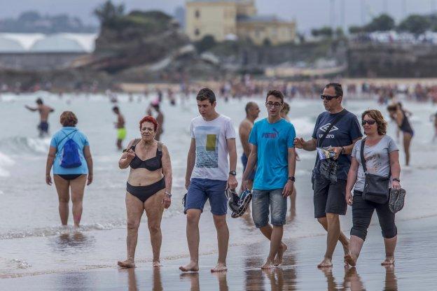 Un grupo de turistas pasea por la orilla de la segunda playa del Sardinero el pasado sábado durante otra jornada nublada.