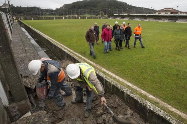 Operarios trabajan en la mejora del campo de fútbol de Escobedo. /DM