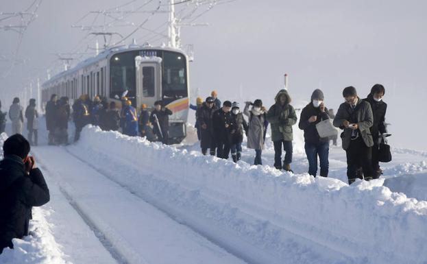 Varios pasajeros abandonan el tren detenido. /Reuters