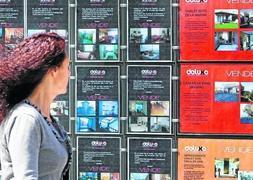 Una joven observa el escaparete de una inmobiliaria en Santander. / Roberto Ruiz/
