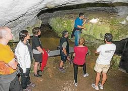 Uno de los grupos que visitaron ayer la cueva de Chufín atiende a las explicaciones del guía. / Foto: José García/