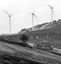 Los aerogeneradores ya comparten espacio con las típicas cabañas pasiegas en la Montaña Oriental. / ROBERTO RUIZ/