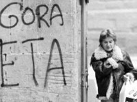 Una mujer pasa delante de una pintada a favor de ETA en Pamplona. / AP/