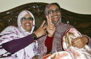 Aminatu Haidar (dcha.), ayer, en su casa de El Aaiún, hace el gesto de la victoria, junto a la también activista saharaui Elghalia Djimi. ::
EFE/