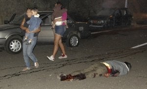 Una familia pasa ante el cadáver de un sicario asesinado en un ajuste de cuentas en Sinaloa. ::
EFE/