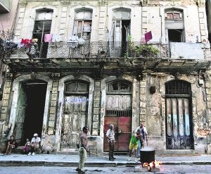 Un grupo de cubanos cocina una 'caldosa' en una calle de La Habana ante una destartalada casa. ::
REUTERS/