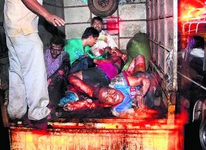 Una camioneta traslada al hospital a varios heridos en la explosión del bazar de Zaveri, la primera de las tres ocurridas en Bombay. ::
AP/