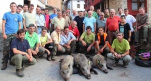 Componentes de la cuadrilla 36, capitaneada por Santos Gómez, con los tres jabalíes que abatieron en Peña Salvorón. ::
PEDRO ÁLVAREZ/