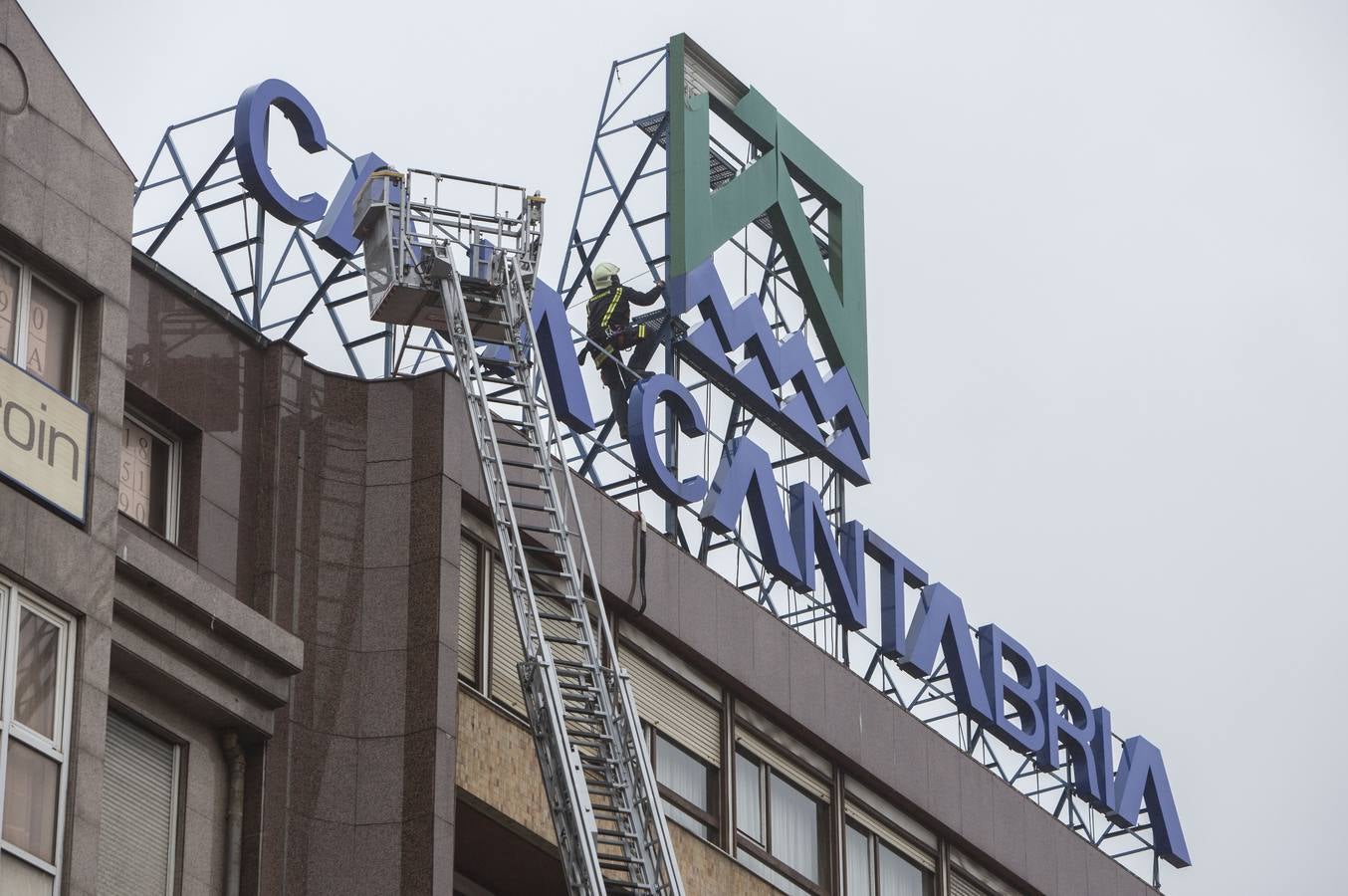 Los bomberos evitan la caída de un gran cartel