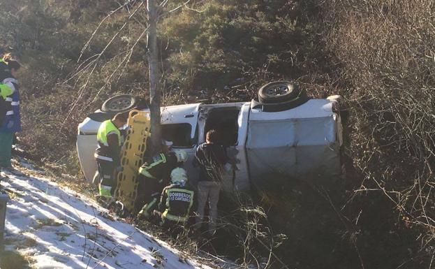 Los bomberos excarcelan a un conductor tras una salida de vía con vuelco en Campoo de Yuso