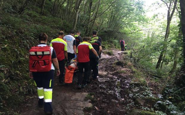 Rescatadores del 112 portean en camilla a un senderista herido en Vega de Pas