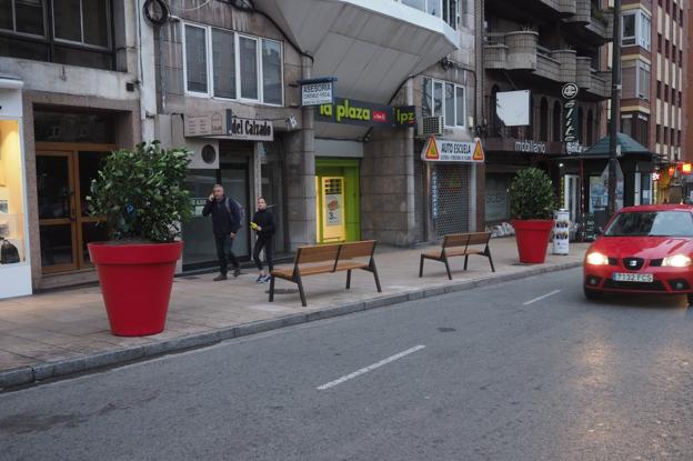 Maceteros y bancos en la calle San Fernando para evitar que los coches suban a la acera