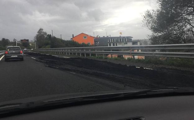 Un camión pierde su carga de tierra por la autovía, a la altura de Mompía