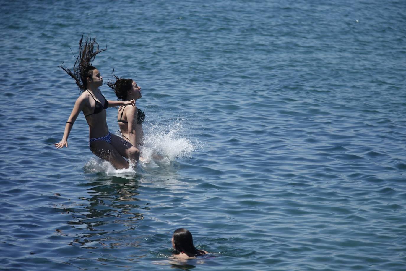 Palas, selfis, mucha gente y chapuzones felices en las playas de Santander