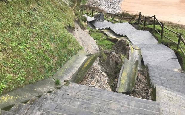 El temporal destroza las escaleras de acceso a la playa de Langre, inunda calles y tira árboles y luces de Navidad