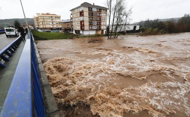 El puente colgante de Ocejo, en Luena, a punto de ser tragado por la riada del Pas