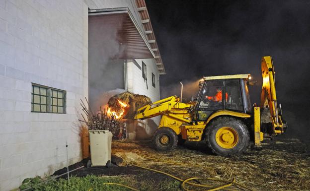 Arden toneladas de pacas de alfalfa en una nave ganadera de Cabezón de la Sal