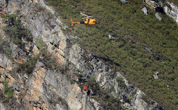 Un helicóptero elimina las rocas sobre la carretera de Polaciones