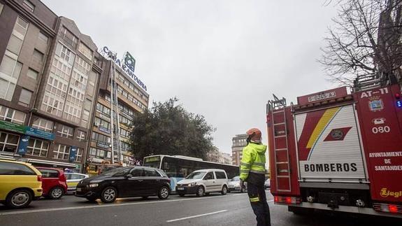 El viento suelta un gran cartel de Caja Cantabria en una azotea del centro