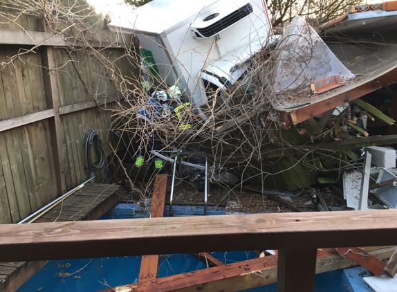 Una camioneta embiste a una furgoneta de reparto y acaba empotrada en el cierre de una vivienda